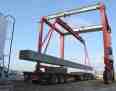 Mobile straddle transporter to lift and store wind tower sections with spreader